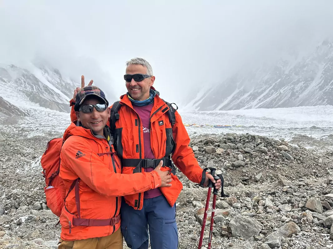 hussain-aziz-k2-adventure-with-foreign-trekkers-cloudy-day Hussain Aziz, CEO of K2 Adventure, posing with foreign trekkers under a cloudy sky during the K2 and Gondogoro La Trek